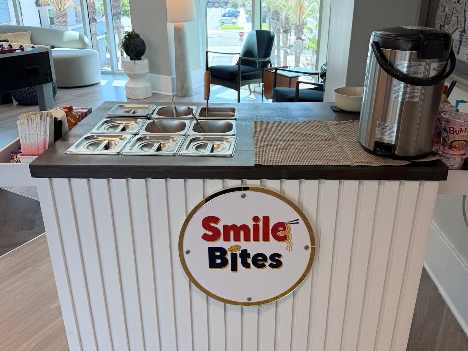 The SmileBites cart set up indoors, with toppings wells along the counter and the SmileBites logo on the front